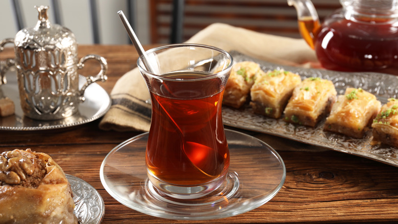 Turkish tea and sweets served on a wooden table.