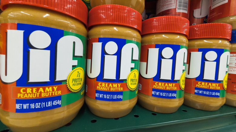 Four jars of Jif peanut butter on a store shelf