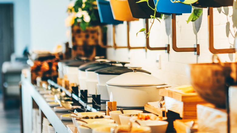 A tidy hotel buffet, with large covered pots and clean serving utensils