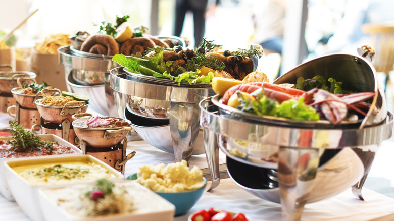 A luxury buffet with main dishes, condiments, toppings, sauces, salads and desserts
