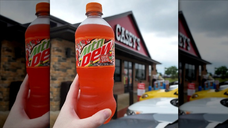 Hand holding Mountain Dew Overdrive in front of Casey's store