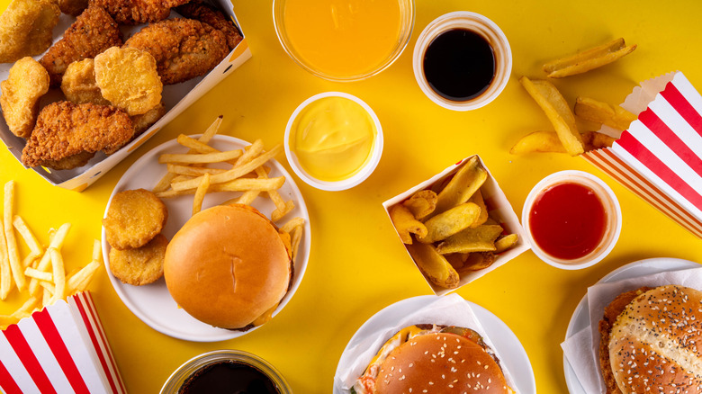 Overhead view of several fast food burgers, fries, chicken, and sauces