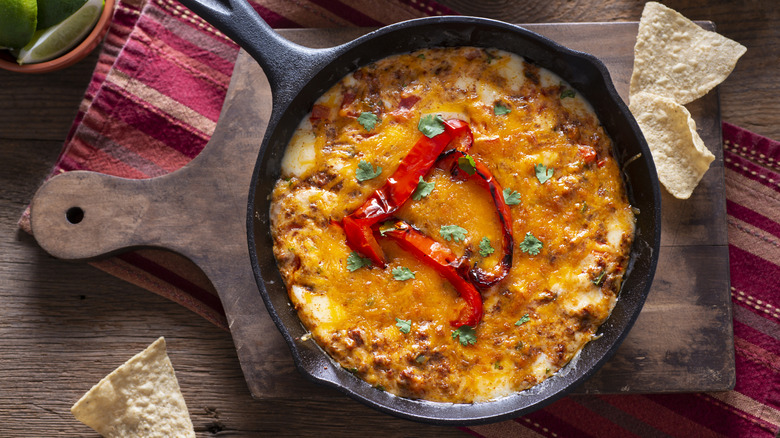 Mexican queso dip served in a cast iron skillet with chips