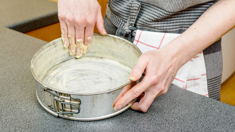 Hand greasing a springform pan
