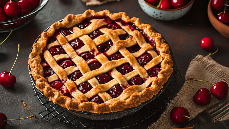 homemade cherry pie with a perfect lattice-top crust surrounded by fresh cherries