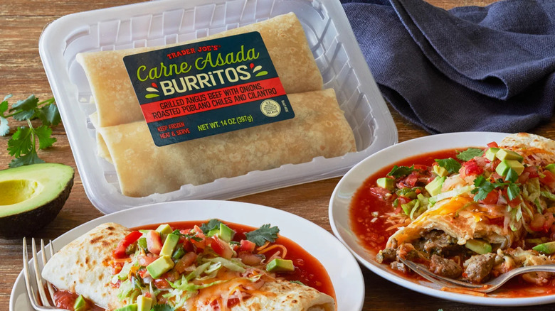a package of premade carne asada burritos on a table with two plates of carne asada burritos in sauce.