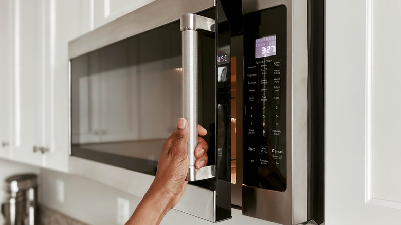 Hand opening microwave slightly
