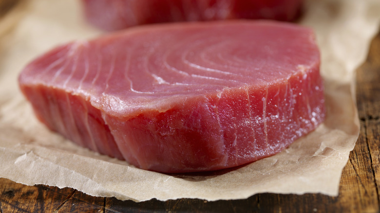 raw ahi tuna steaks sitting on top of parchement paper