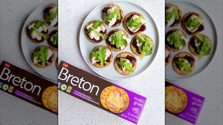 Breton crackers topped with cranberry sauce, turkey, and greens