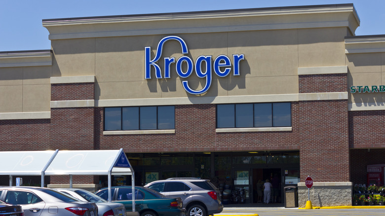 The blue Kroger logo on the brown wall of one of its stores