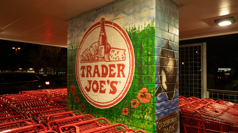 An interior pillar with a Trader Joe's logo painted on it, and lots of greenery and flowers