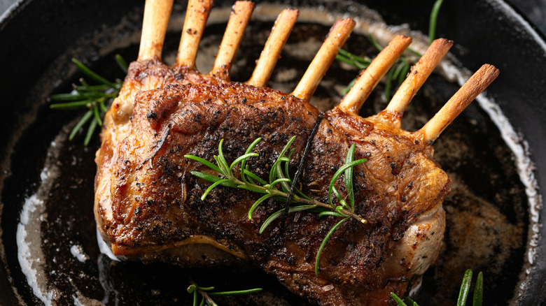Rack of lamb in a cast iron pan with fresh rosemary