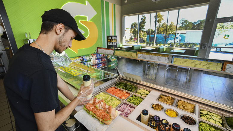 Subway employee preparing sandwich