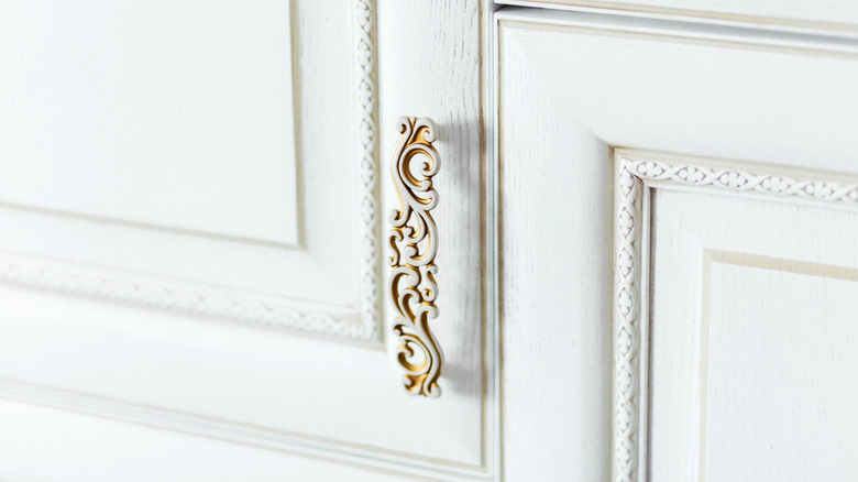 Close-up of ornate detail and handle hardware on kitchen cabinets
