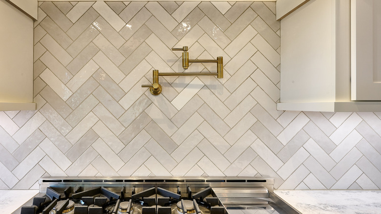 Pot filler faucet placed on the backsplash above a gas range