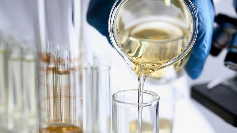 A food scientist pouring syrup into a glass container
