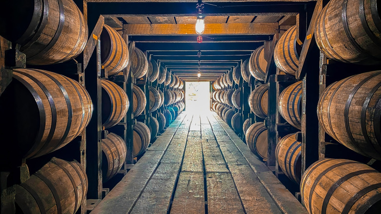 Rows of bourbon barrels aging in a rickhouse