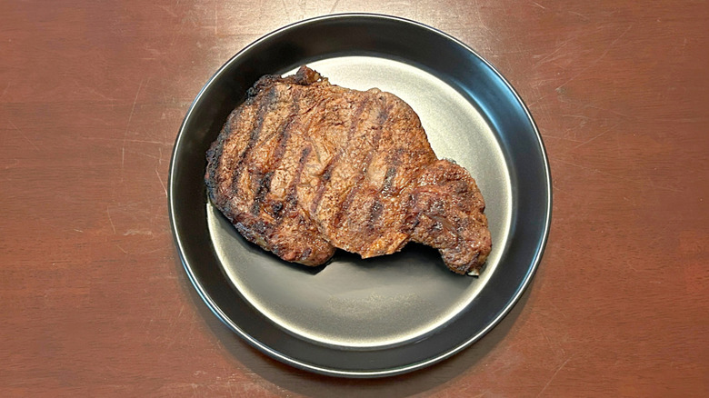 Longhorn Steakhouse Outlaw Ribeye steak on a black plate against a wood surface