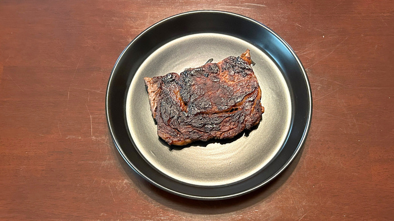 Longhorn Steakhouse ribeye on a black plate against a wood surface