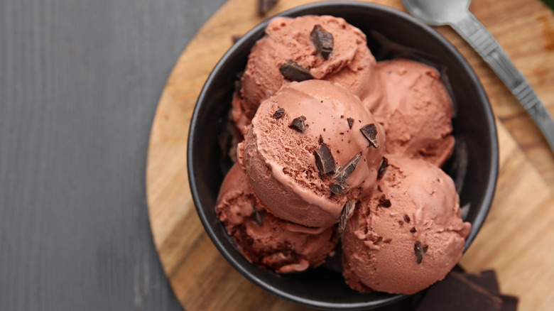 overhead shot of a bowl of chocolate ice cream on a wood board
