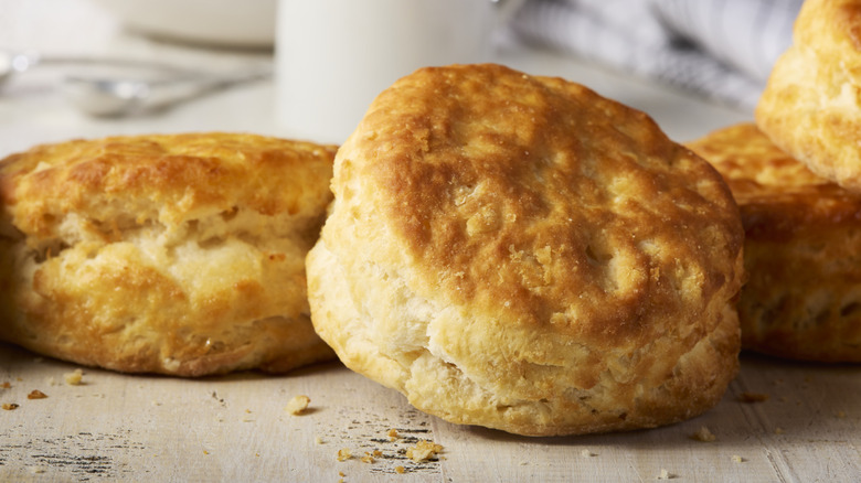 Golden brown biscuits with visible flecks of salt arranged on a table.