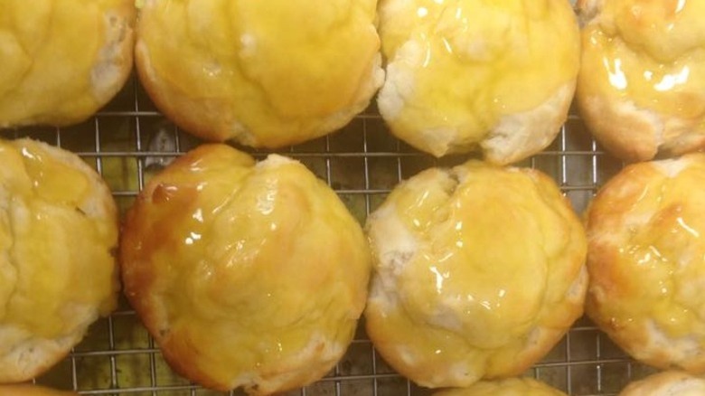 A tray of glistening honey butter biscuits lined up end to end.