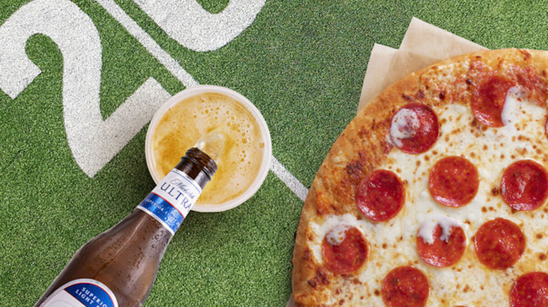 Pepperoni pizza and beer on football field