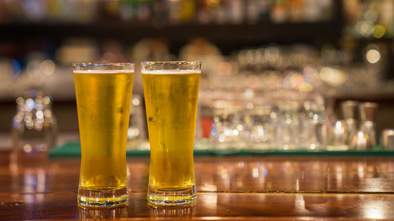 Two glasses of cold beer on a bar counter