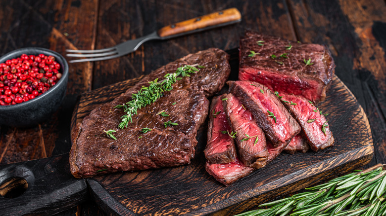 Grilled marinated skirt steak on wooden cutting board