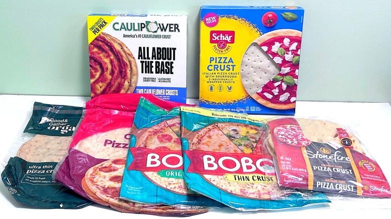 Seven different pizza crusts together on a green and white background