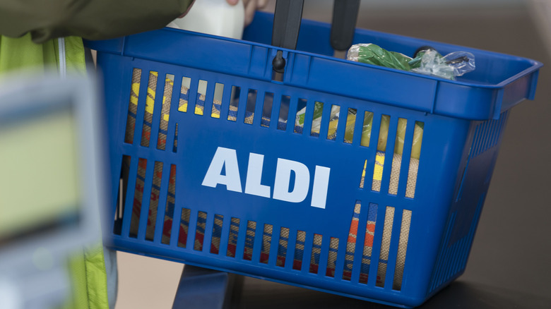 Person removing grocery items from blue Aldi basket