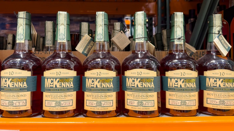 A lineup of Henry McKenna 10 Year Single Barrel Bourbon bottles in a store