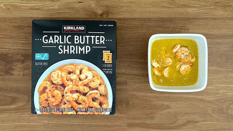 Kirkland Signature Garlic Butter Shrimp package and prepared shrimp in white bowl