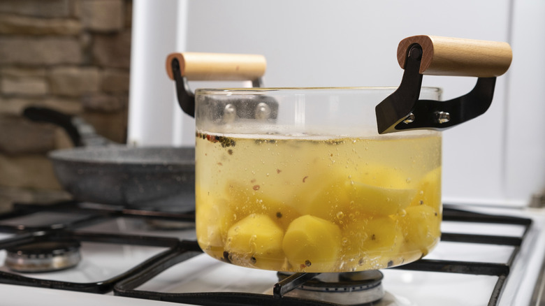A boiling pot of potatoes on a cookstove