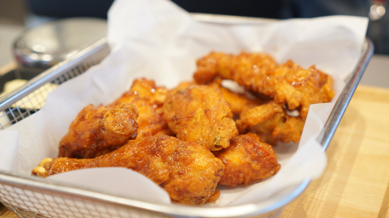 fried chicken in a wire serving container on a counter
