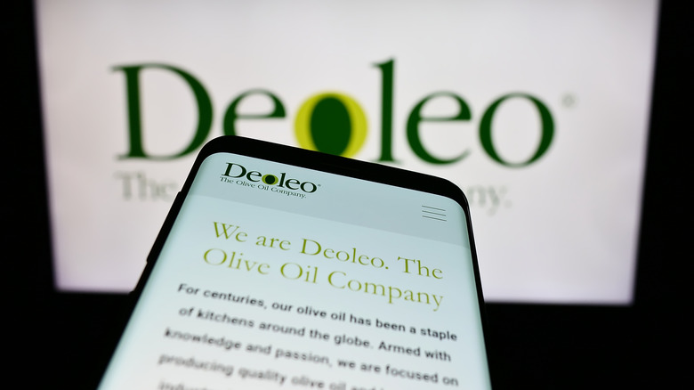 DeoLeo Olive Oil on a screen with a phone in front of it