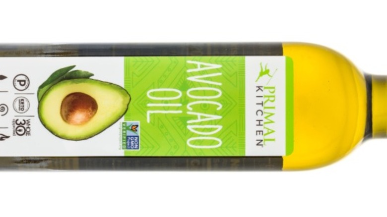 A bottle of Primal Kitchen Avocado Oil against a black background