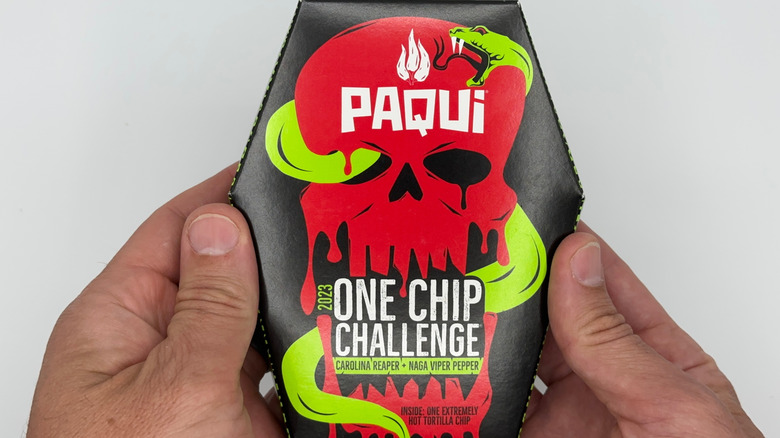 two hands holding a Paqui One Chip Challenge package