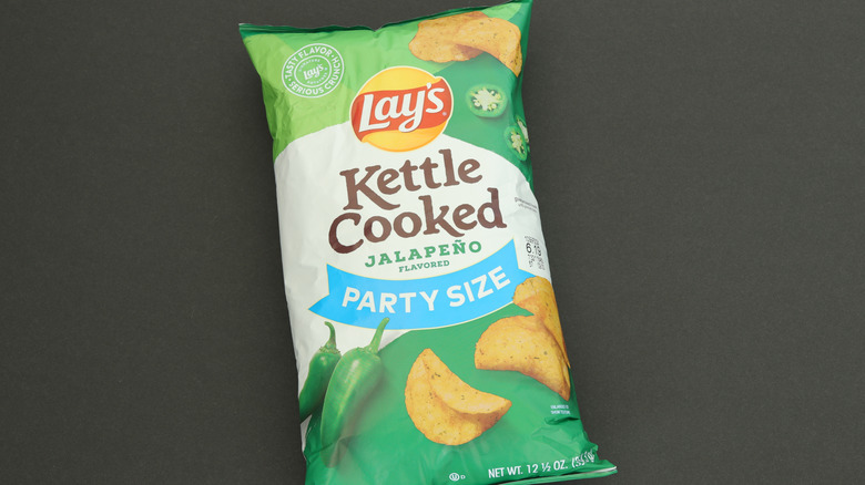 A bag of Lay's Kettle Cooked Jalapeño chips on a black backrgound