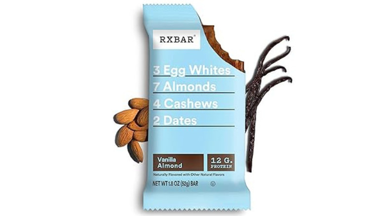 A Vanilla Bean RXBAR against a white backdrop with Vanilla and Cashews in the back