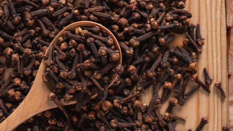 whole cloves and wooden spoon