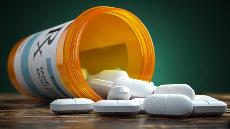 prescription pills and open bottle on side