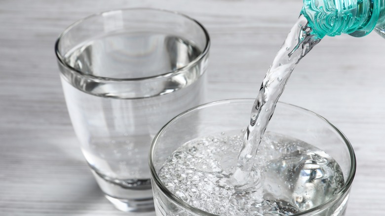 pouring sparkling water into glasses