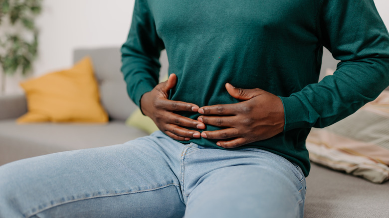 person holding stomach with hands