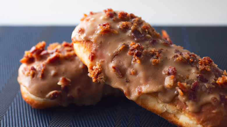 A pair of maple bacon bars, showing the texture of the crumbled bacon on the icing