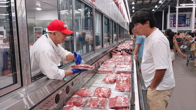 Costco employee assisting customer in meat department