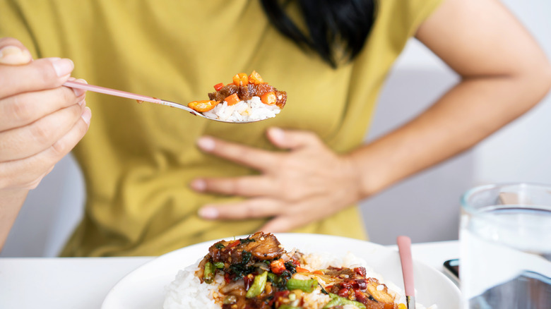 Woman holding stomach from spice