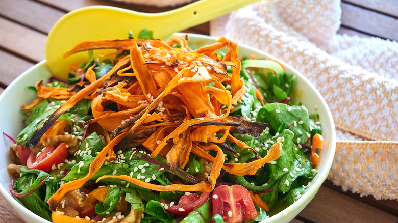 A table with a big bowl of salad on it