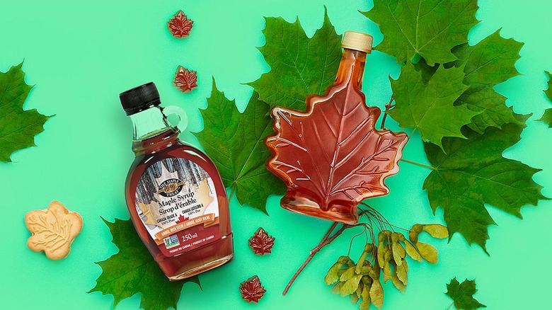 Bottles of The Maple Treat maple syrup with maple leaves