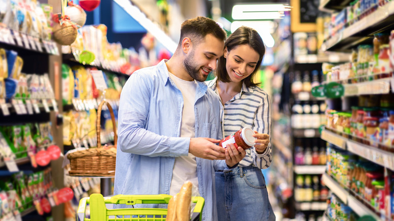 couple looking at jars of sauce